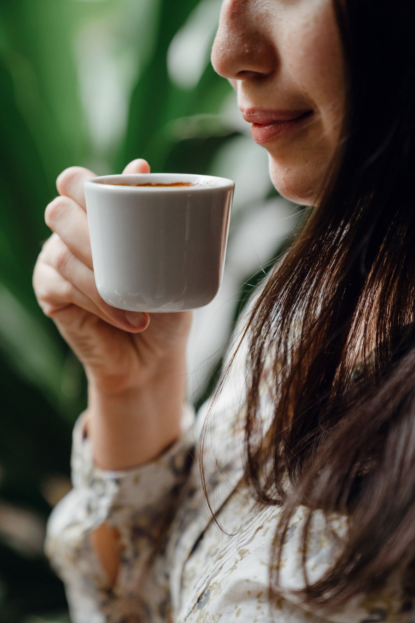 Person pausing to taste a fresh espresso in a quiet cafe