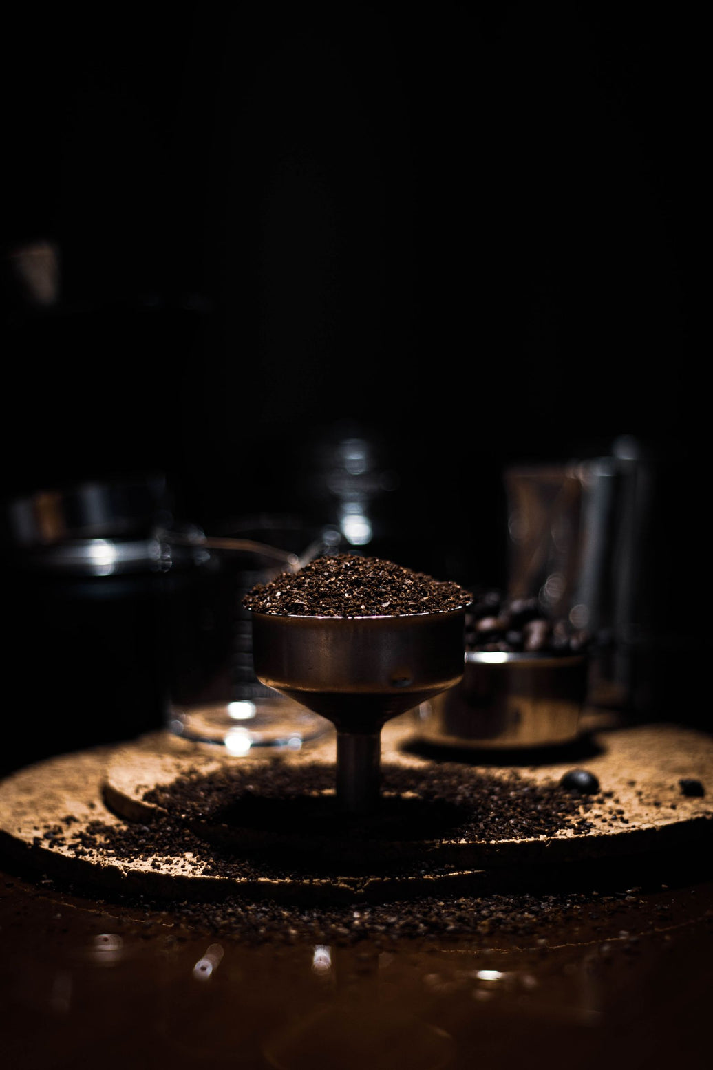 Coffee grinder with leftover grounds on a dark wooden surface