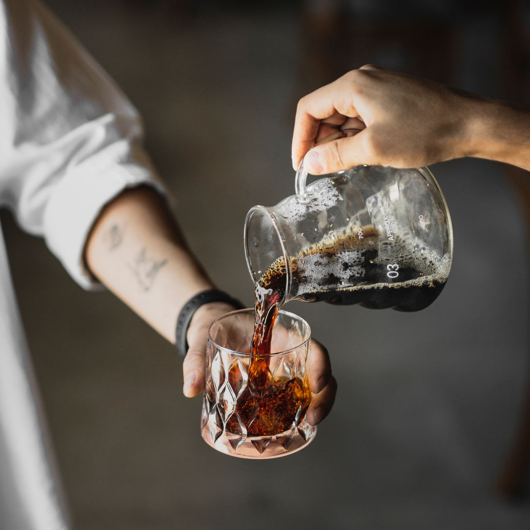 Cold brew concentrate poured from a pot into a glass