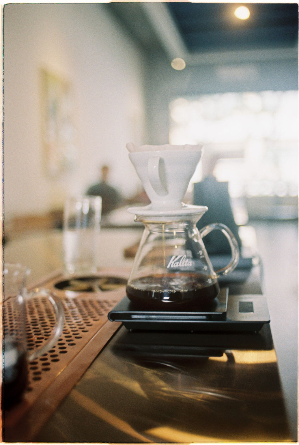 Flat-bottom Kalita dripper brewing coffee in a cozy cafe corner