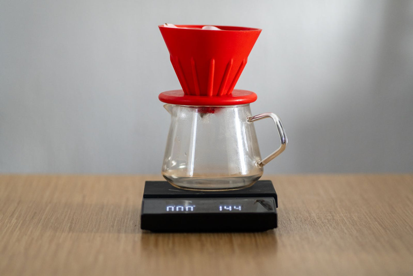 Red V60 dripper brewing a recipe onto a digital scale