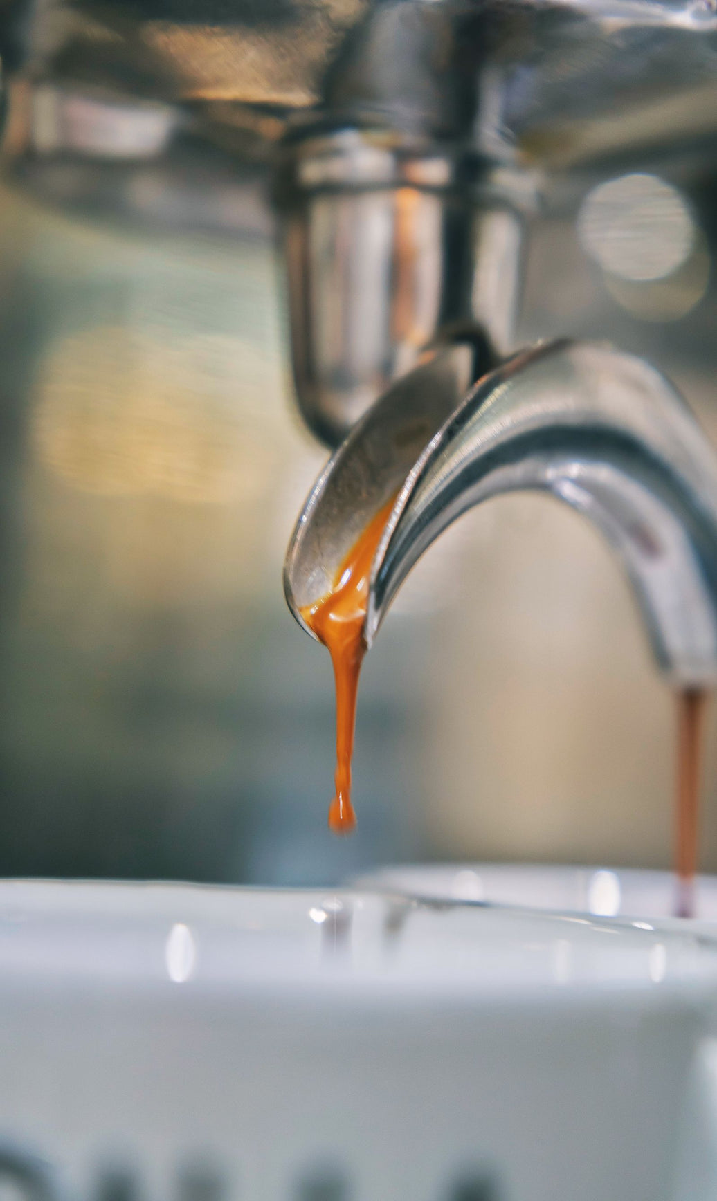 Espresso extraction dripping from a bare portafilter mid-shot