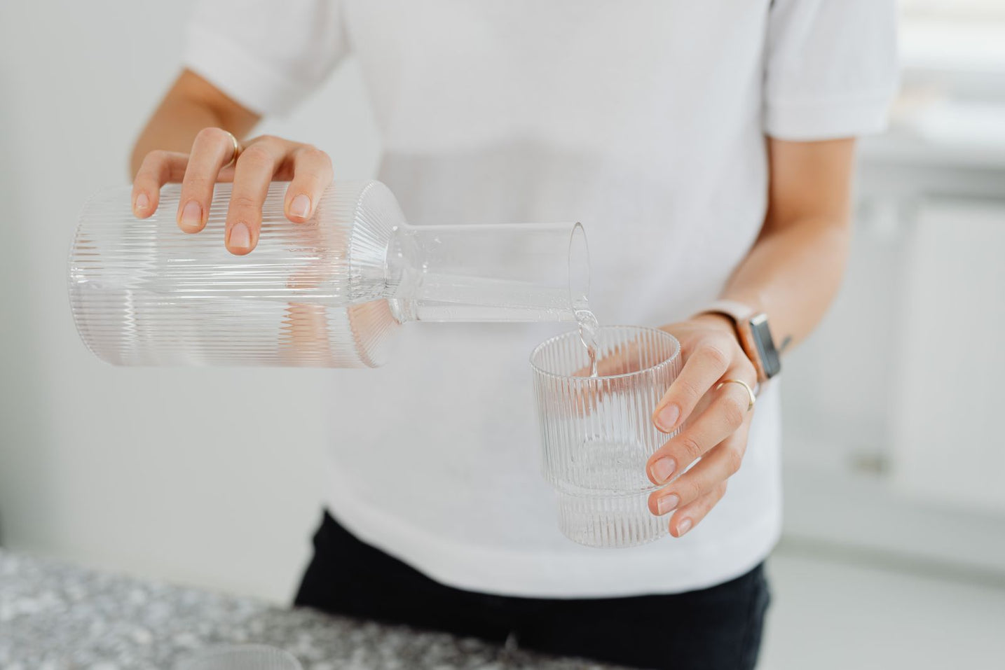 Clean water poured from a carafe into a clear glass