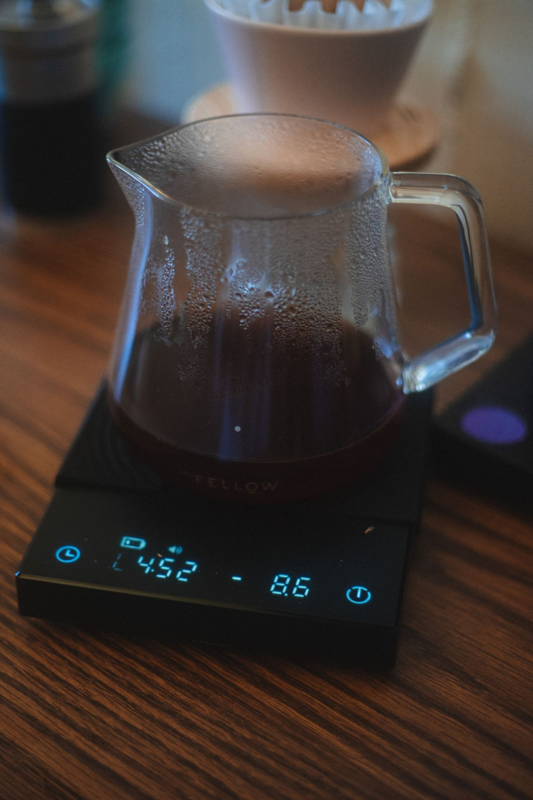 Digital coffee scale weighing a glass pot during a slow brew