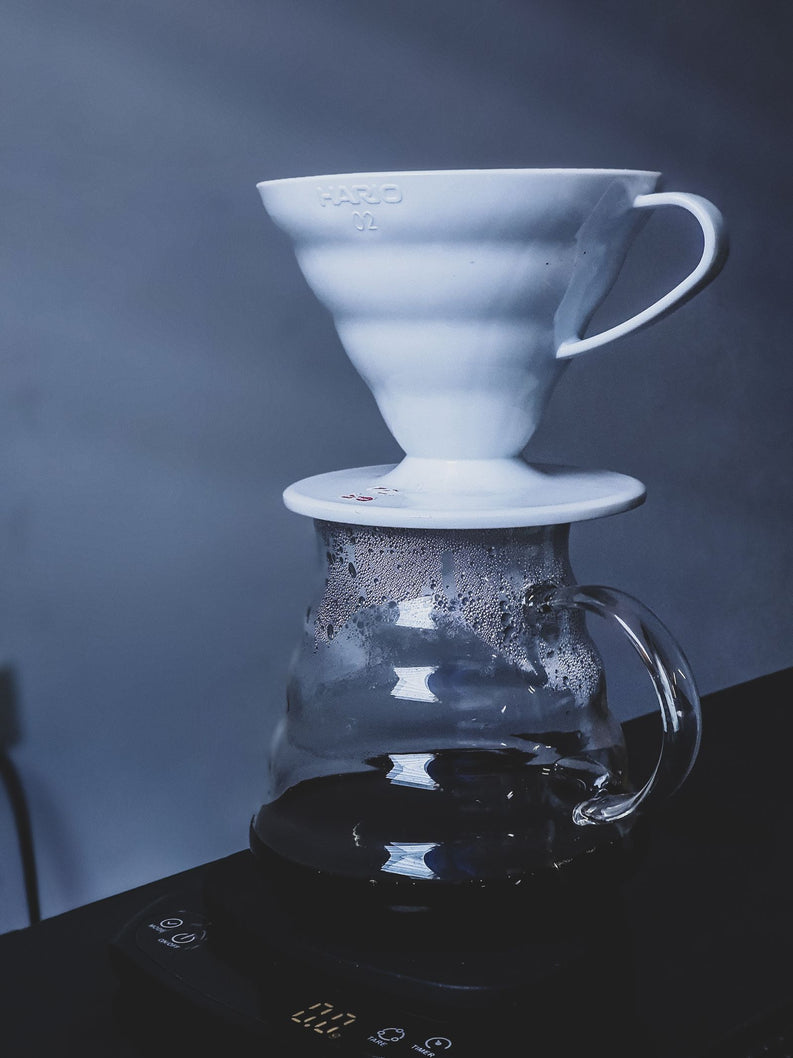 Coffee scale under a glass carafe and dripper mid-brew