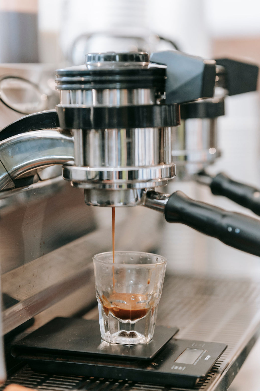 A fast espresso stream pouring from the machine into a glass