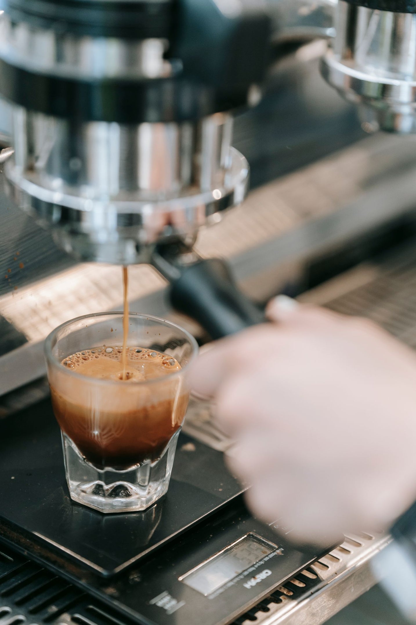 Dark espresso shot with heavy crema brewing into a shot glass